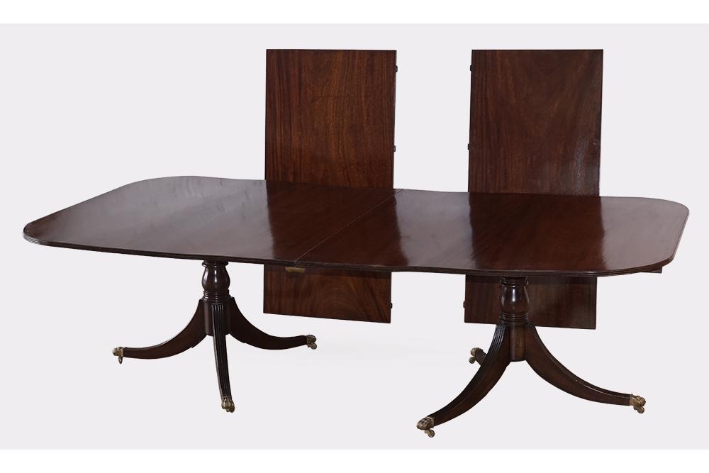 An English Mahogany Double Pedestal Dining Table.: An English Mahogany Double Pedestal Dining Table. Raised on brass capped paw feet, with two leaves (one leaf: 26" wide, the other 27" wide) 29 1/2" x 105" x 54"