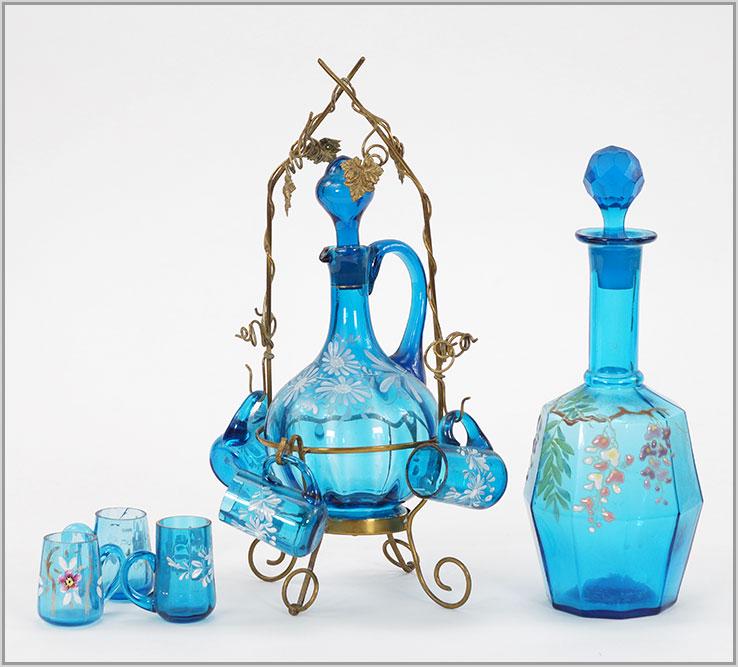 Blue Enameled Glass Decanters and Glasses.: Blue Enameled Glass Decanters and Glasses. Consisting of a blue enameled glass wine decanter in a gilt metal frame with four small matching glasses. Together with another blue enameled glass decanter 