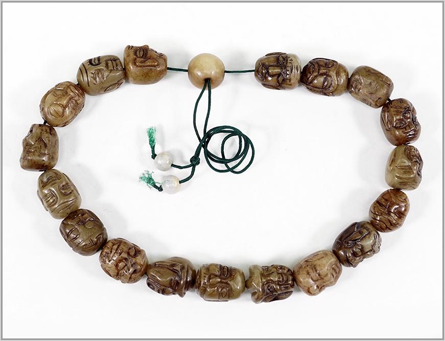 A Strand of Soapstone Beads.: A Strand of Soapstone Beads. 18 carved soapstone beads in the form of heads with one round soapstone bead at the end Average bead: 1" x 3/4"