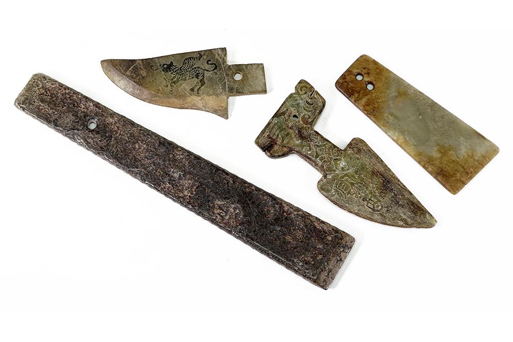Two Chinese Jade Axes.: Two Chinese Jade Axes. The larger bearing an intricate interwoven pattern and character marks on the verso. Together with two carved stone daggers Longer: 12 3/4"