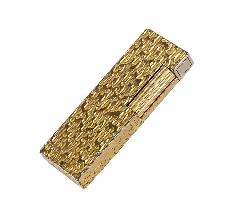 A Dunhill Rollagas Lighter.: A Dunhill Rollagas Lighter. Goldplated bark design lighter, marked Dunhill and Japan Length: 2 3/4"