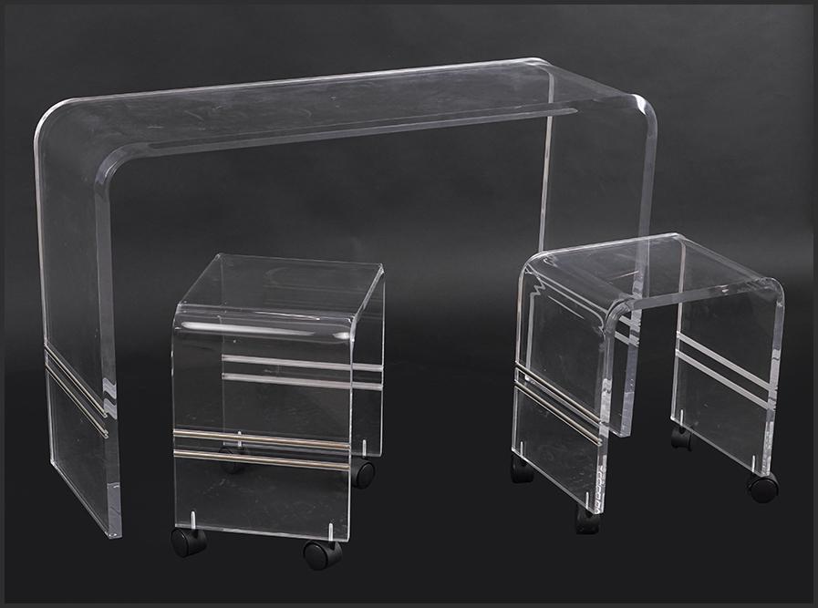 A Suite of Lucite Furniture.: A Suite of Lucite Furniture. Comprising a waterfall style console table (28 1/2" x 44" x 15") and a pair of stools / ottomans raised on casters (18" x 15" x 12")