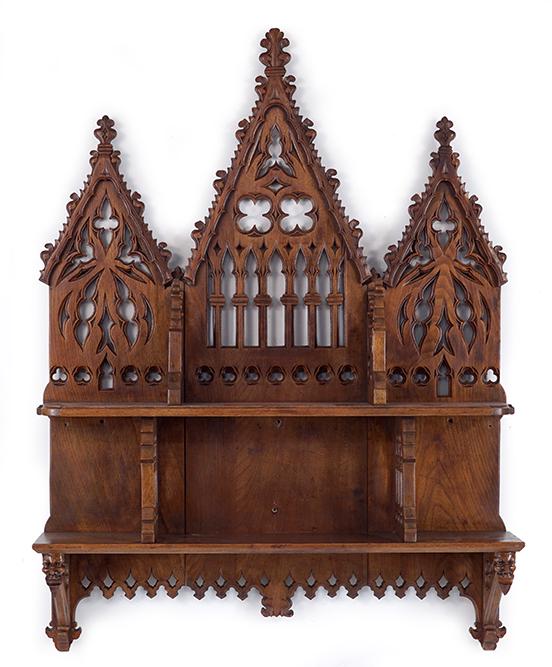 19th C Gothic Revival Carved Oak Shelf Unit.: 19th C Gothic Revival Carved Oak Shelf Unit. Featuring a 19th Century Gothic shelf unit with three cathedral style peaks and two shelves. The bottom shelf bears carved devil heads on each side 46" x 3
