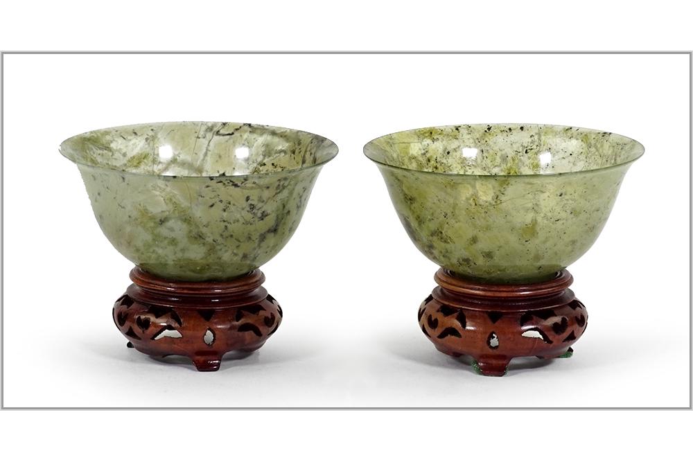 A Pair of Chinese Spinach Jade Bowls.: A Pair of Chinese Spinach Jade Bowls. Raised on wood stands Jade bowl: 2" x 4"