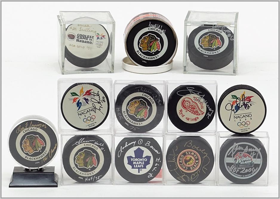 TWELVE SIGNED HOCKEY PUCKS.: TWELVE SIGNED HOCKEY PUCKS. Consisting of Chicago Blackhawks, Toronto Maple Leafs, Detroit Red Wings and the 1998 Olympic's