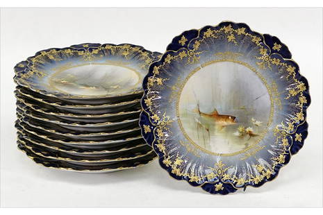 A Set of Eleven Limoges Porcelain Fish Plates.: A Set of Eleven Limoges Porcelain Fish Plates. Painted centers with transfer decorated and gilt cobalt porcelain borders Diameter: 9"