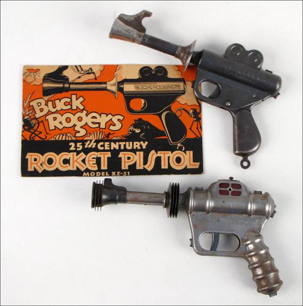 BUCK ROGERS ATOMIC PISTOL.: BUCK ROGERS ATOMIC PISTOL. Together with a Buck Rogers Rocket Pistol and an advertisement for the rocket pistol. Both manufactured by Daisy
