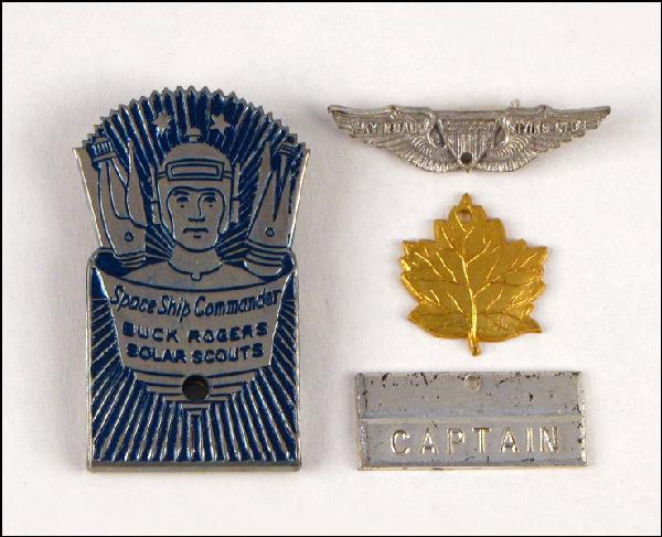 SKY ROADS FLYING CLUB PIN AND LEAF CHARM.: SKY ROADS FLYING CLUB PIN AND LEAF CHARM. Reverse of pin and charm both read "John F. Dille Company, Chicago". Together with a Buck Rogers captain badge, and a Buck Rogers Space Ship Commander badge