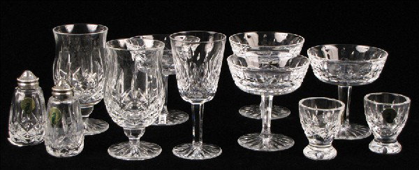 COLLECTION OF WATERFORD CRYSTAL GOBLETS AND TAB: COLLECTION OF WATERFORD CRYSTAL GOBLETS AND TABLE ARTICLES IN THE LISMORE PATTERN. Comprised of four champagne/sherbets, one wine goblets, two egg cups, one pair of salt and pepper shakers, and two go