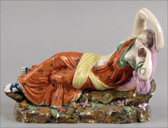 STAFFORDSHIRE PEARLWARE RECLINING CLEOPATRA, ON: STAFFORDSHIRE PEARLWARE RECLINING CLEOPATRA, ON ROCKY BASE. Height: 9", Length: 13"