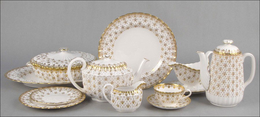 SPODE BONE CHINA DINNER SERVICE IN THE FLEUR-DE: SPODE BONE CHINA DINNER SERVICE IN THE FLEUR-DE-LYS GOLD PATTERN. Comprised of 14 dinner plates, 14 salad plates, 14 bread plates, 13 teacups, 14 saucers, two oval vegetable dishes, two large oval pla