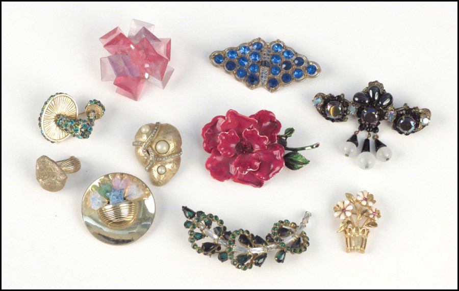 COLLECTION OF BROOCHES.: COLLECTION OF BROOCHES. Including a Vogue sterling silver, green and white rhinestone brooch, a Mylo floral brooch, a Kramer black bead brooch, a Hattie Carnegie faux pearl and rhinestone shell brooch