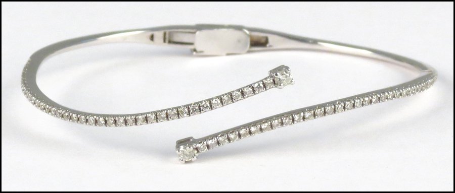 14 KARAT WHITE GOLD AND DIAMOND BYPASS BANGLE : 14 KARAT WHITE GOLD AND DIAMOND BYPASS BANGLE BRACELET. 12.1 grams