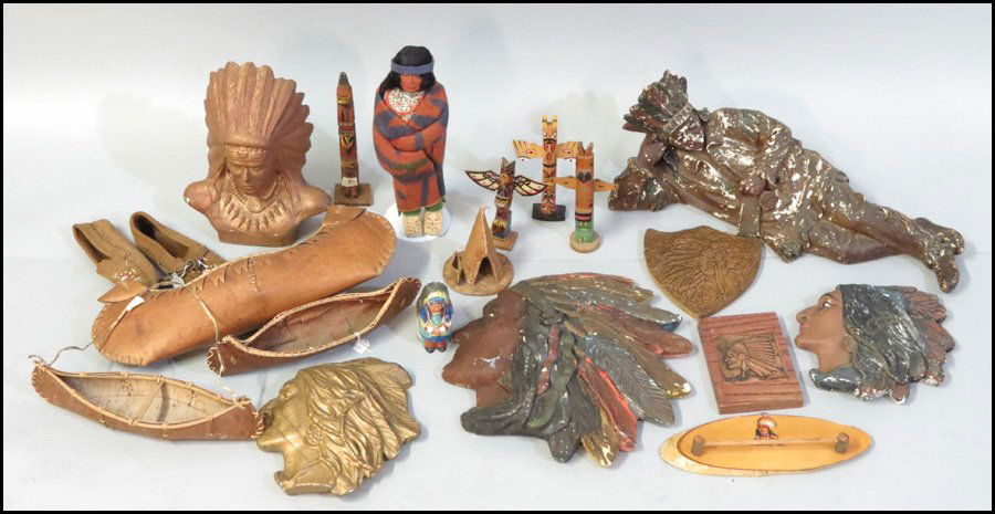 A COLLECTION OF INDIAN MOTIF DECORATIVE ITEMS.: A COLLECTION OF INDIAN MOTIF DECORATIVE ITEMS. Comprised of five indian head wall plaques, a reclining plaster indian figure, and indian doll, three birch bark canoes, various other indian motif decor