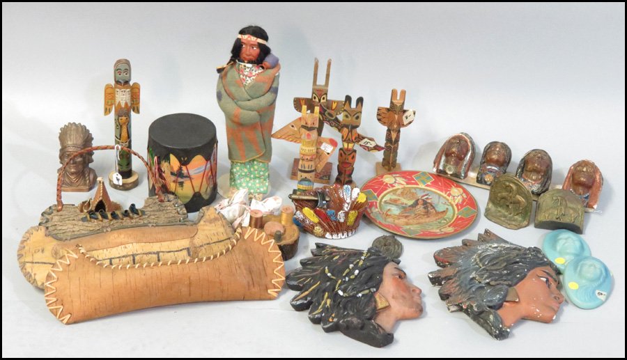 COLLECTION OF INDIAN MOTIF DECORATIVE ITEMS.: COLLECTION OF INDIAN MOTIF DECORATIVE ITEMS. Including three bark canoes, five indian head wall plaques, an indian doll, a toy drum, six wooden totem poles, a painted metal plate, a cigar holder, a pa