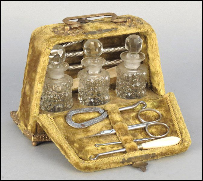 A VICTORIAN VELVET TRAVELING BOX.: A VICTORIAN VELVET TRAVELING BOX. Opening on both sides to reveal three glass bottles along the middle, writing implements along one side, and button hooks along the other side Box: 4" x 6.5" x 3"