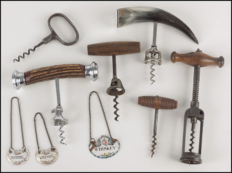 GROUP OF CORKSCREWS.: GROUP OF CORKSCREWS. Comprised of an antler handled corkscrew, a horn handled corkscrew, three wood hadled corkscrews, and one metal corkscrew. Together with three enamel deacnter tags