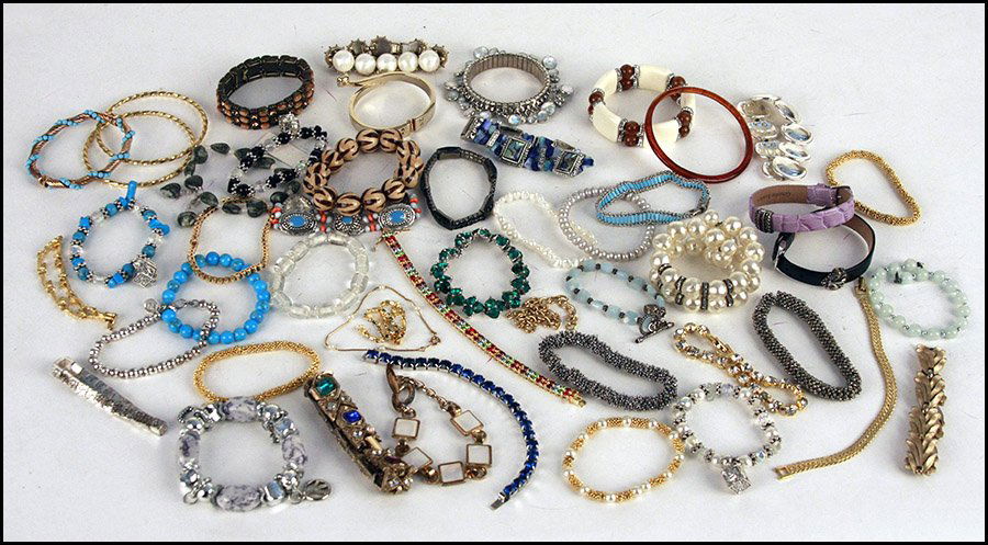 GROUP OF LINE, COIL, AND LINK BRACELETS.: GROUP OF LINE, COIL, AND LINK BRACELETS. Including pieces by Bogoff, Napier, Trifari, Joan Rivers, Monet, and others