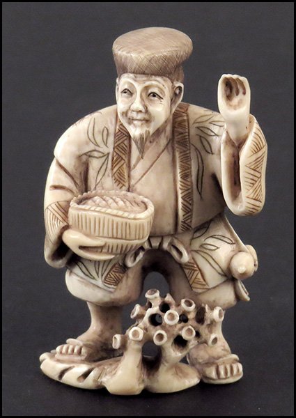 CARVED IVORY NETSUKE OF A MAN.: CARVED IVORY NETSUKE OF A MAN.