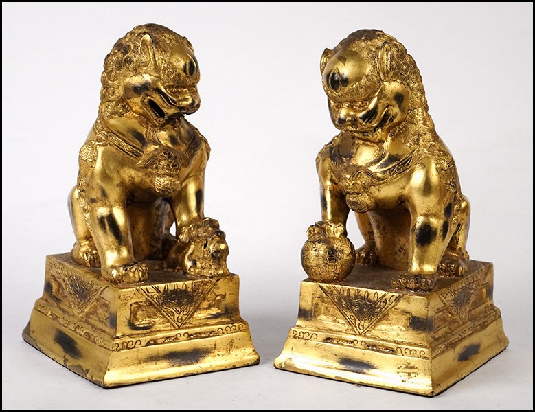 PAIR OF PATINATED GILT METAL FOO DOGS.: PAIR OF PATINATED GILT METAL FOO DOGS. Height: 13.5"