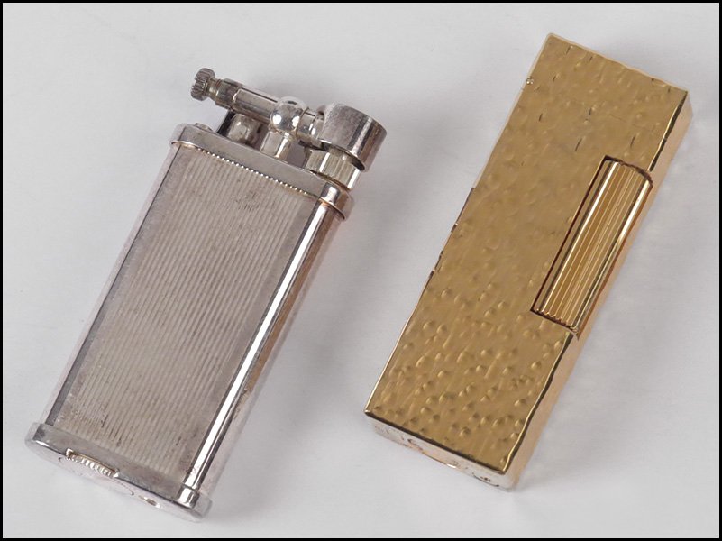 TWO DUNHILL LIGHTERS.: TWO DUNHILL LIGHTERS. One Rollagas, made in Switzerland. One silver plated, made in England. Both in original Dunhill boxes H: 2.5'' and 2.75''