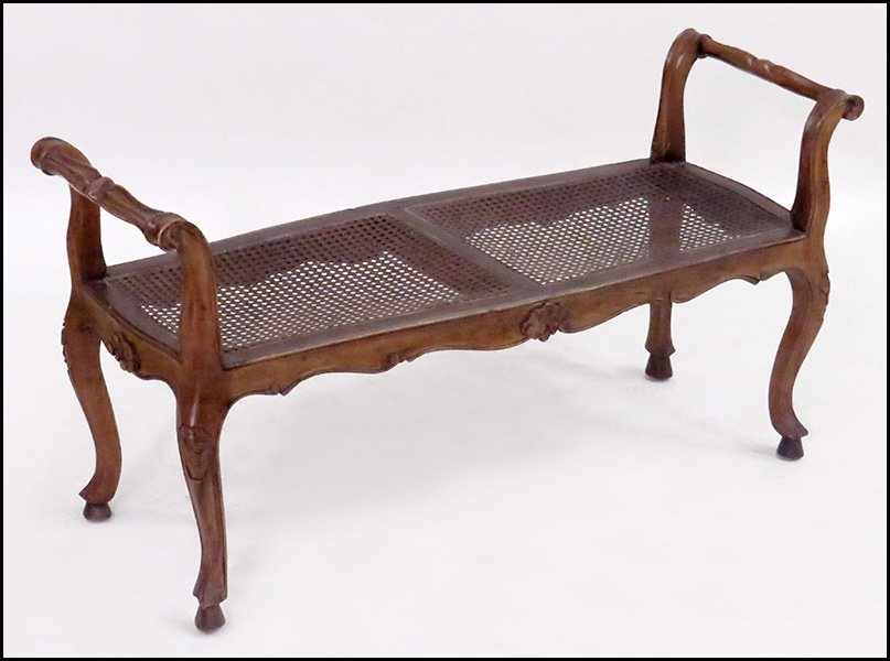 FRENCH PROVINCIAL STYLE WALNUT WINDOW BENCH.: FRENCH PROVINCIAL STYLE WALNUT WINDOW BENCH. Bearing a cane seat 22'' x 43'' x 18''