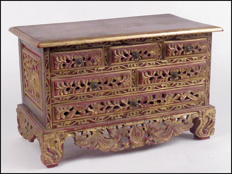CARVED AND PAINTED WOODEN CHEST.: CARVED AND PAINTED WOODEN CHEST. Painted red with gold accents, bearing three small upper drawers, two medium in the middle and one larger drawer lower. Dated 1900 on the back 13.5" x 21.5" x 12.5"