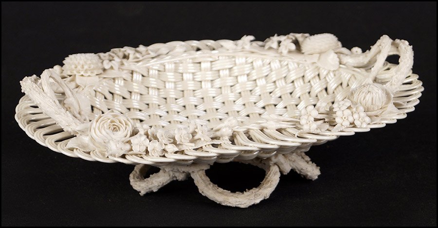 BELLEEK PORCELAIN BASKET.: BELLEEK PORCELAIN BASKET. Oval openwork basket with Parian porcelain applied flowers, stem form handles, and stem form legs. There is a slight iridescence to the woven porcelain glaze and the undersid