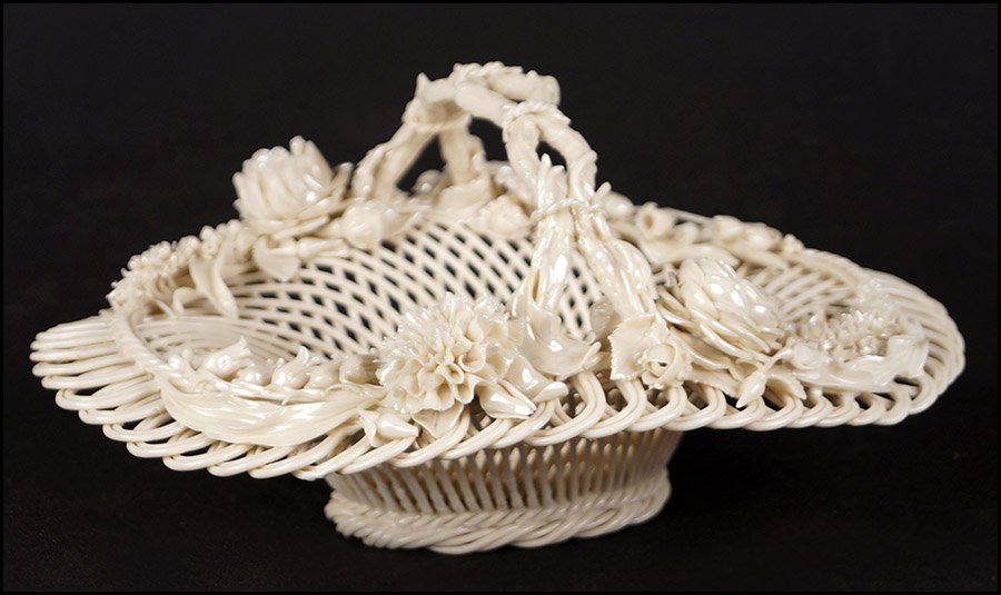 BELLEEK PORCELAIN HANDLED BASKET.: BELLEEK PORCELAIN HANDLED BASKET. Oval form openwork porcelain basket with slight iridescence to the glaze and applied porcelain flowers fanning out from the stem form handle 5" x 11" x 9"