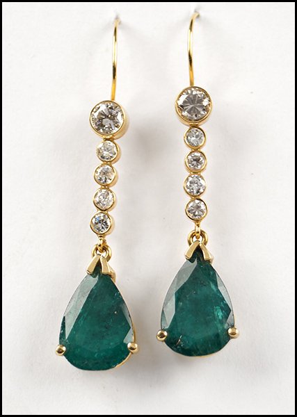 PAIR OF EMERALD, DIAMOND, AND 14 KARAT YELLOW GOLD: PAIR OF EMERALD, DIAMOND, AND 14 KARAT YELLOW GOLD DROP EARRINGS. Comprised of two pear shaped emeralds which are 2.30 carat each. Five bezel set round diamonds are J-K-L color, SI1-SI2 clarity, and t