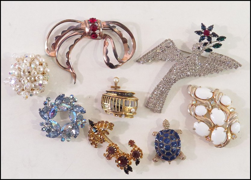 MARY DAN WHITE RHINESTONE BIRD BROOCH.: MARY DAN WHITE RHINESTONE BIRD BROOCH. Together with a Tortolani gold tone and faux pearl cable car brooch, a Ciner enamel turtle brooch, a Nettie Rosenstein sterling silver bow brooch, a Schiaparelli