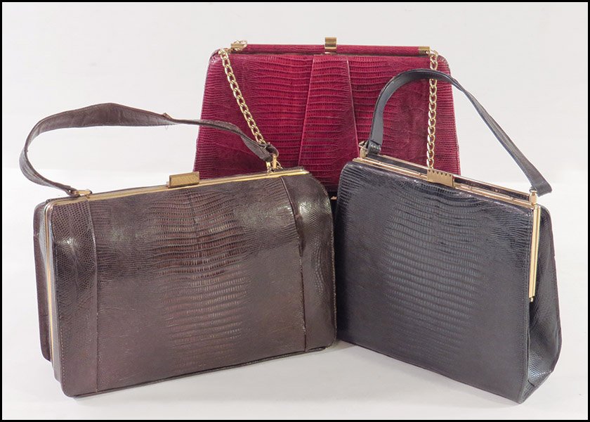 THREE LIZARD SKIN HANDBAGS.: THREE LIZARD SKIN HANDBAGS. Comprised of one unlabeled navy bag, one Bellstone red bag with a link strap, and one Escort brown accordion style bag Largest: 8'' x 11.5''