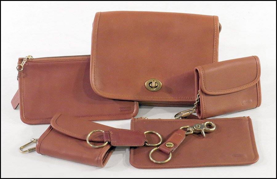 COLLECTION OF COACH BROWN LEATHER ACCESORIES.: COLLECTION OF COACH BROWN LEATHER ACCESORIES. Comprised of two makeup pouches, two keychain coin purses, and two keychains. Together with a brown leather purse by Laura USA Purse: 5.5'' x 8.5''