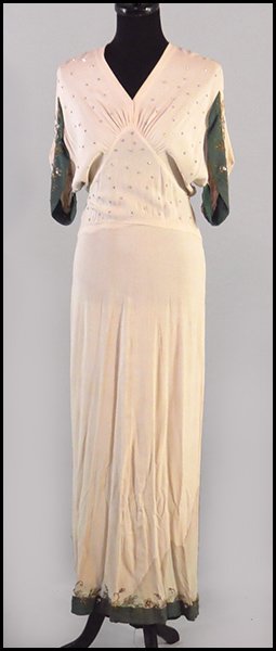 ELSA SCHIAPARELLI CREME AND GREEN CREPE GOWN.: ELSA SCHIAPARELLI CREME AND GREEN CREPE GOWN. Bearing rhinestone applique and soutache embroidery. With a partial button up exposed back. Bearing the original "Schiaparelli" white label Size: Medium