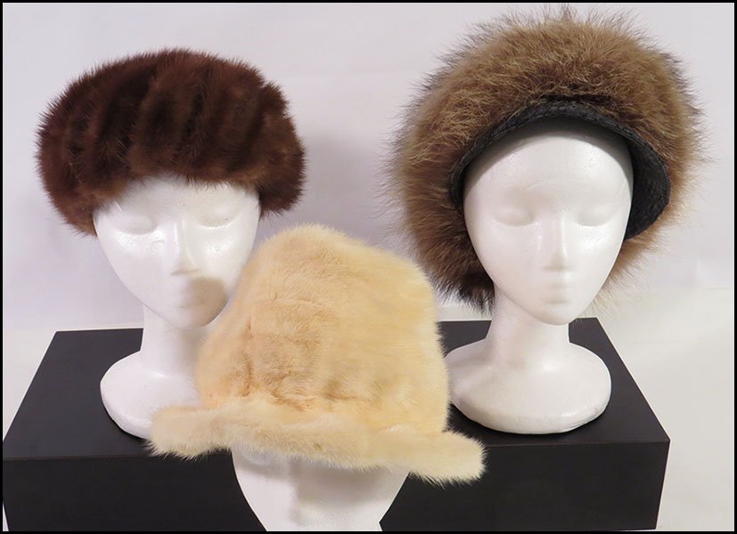 GROUP OF THREE FUR HATS.: GROUP OF THREE FUR HATS. Comprised of one Evans Chicago mink hat, one Marshall Field & Company white mink hat, and one raccoon fur hat