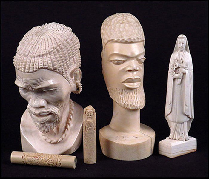 TWO AFRICAN CARVED IVORY BUSTS.: TWO AFRICAN CARVED IVORY BUSTS. One bust is bearing the signature "G. Mareke". Together with a carved bone nun and two Austrian carved resin needle cases Tallest height: 7"