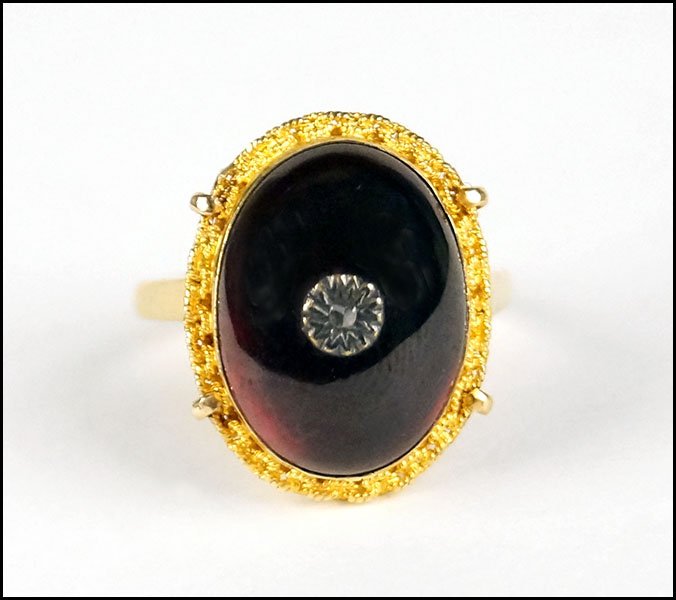 A CABOCHON GARNET AND 14 KARAT YELLOW GOLD RING.: A CABOCHON GARNET AND 14 KARAT YELLOW GOLD RING. Size: 6.25 Wt: 6.9 grams
