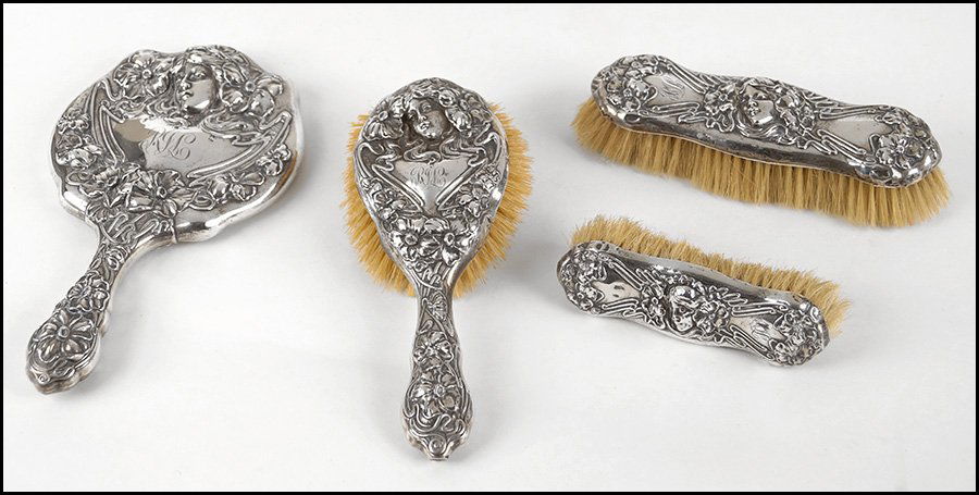 AN ART NOUVEAU STERLING SILVER VANITY SUITE.: AN ART NOUVEAU STERLING SILVER VANITY SUITE. Comprised of a hand mirror, hand brush, and two clothing brushes Mirror: 10" x 5.5"