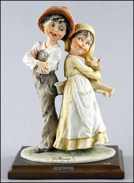 1982 GIUSEPPE ARMANI 'GULLIVER'S WORLD' FIGURAL GROUP: 1982 GIUSEPPE ARMANI 'GULLIVER'S WORLD' FIGURAL GROUP DEPICTING A YOUNG GIRL AND BOY. Mounted on a wood base, bearing incised signature and the Capodimonte mark With base: 10.5" x 7.25" x 5"
