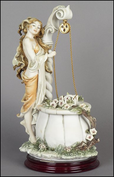 GIUSEPPE ARMANI 'LADY AT THE WELL' FIGURE.: GIUSEPPE ARMANI 'LADY AT THE WELL' FIGURE. Signed on the sculpture. Copyright Florence 1994. Bearing the Capodimonte 'N' crown stamp. Raised on a wood base (H: 1'' Diameter: 6.25''). With original box