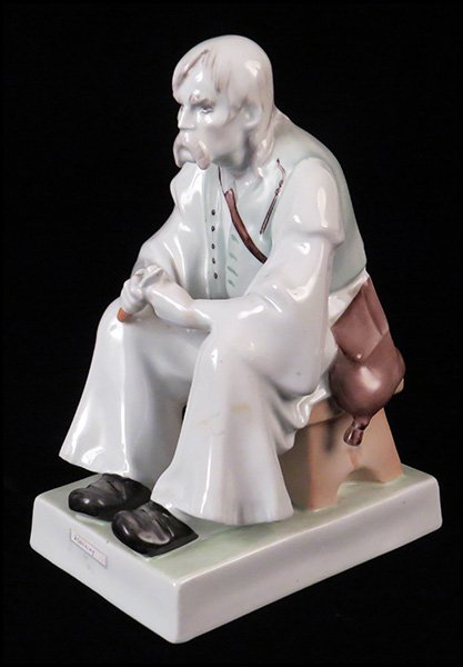 ZSOLNAY PORCELAIN FIGURE OF A SEATED MAN CARVING.: ZSOLNAY PORCELAIN FIGURE OF A SEATED MAN CARVING. H: 12.5" W: 9" D: 6"