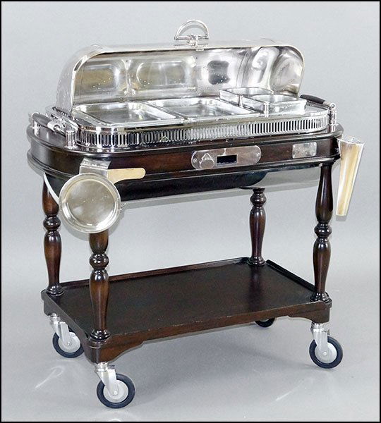 CHRISTOFLE SILVERPLATE AND MAHOGANY ROAST SERVING: CHRISTOFLE SILVERPLATE AND MAHOGANY ROAST SERVING TROLLEY. 44" x 35.5" x 22.5" $600/$1,000 Raised on casters, bearing an attachment for knives and a rest. Includes two gravy and two shallow pan insert