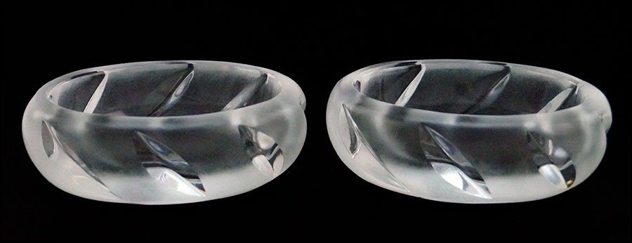 A PAIR OF LALIQUE FROSTED AND CLEAR CRYSTAL SALT: A PAIR OF LALIQUE FROSTED AND CLEAR CRYSTAL SALT CELLARS. H: 1" W: 3" D: 2.25" $75/$125 Signed "Lalique, France"
