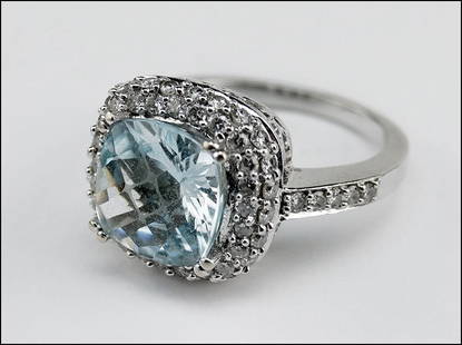 A BLUE TOPAZ, DIAMOND AND 14 KARAT WHITE GOLD RING.: A BLUE TOPAZ, DIAMOND AND 14 KARAT WHITE GOLD RING. Size: 7 Wt: 7.1 grams $200/$400 Comprising a square checkerboard faceted blue topaz surrounded by two rows of prong set round diamonds. Shoulders