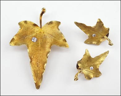 A DIAMOND AND 14 KARAT YELLOW GOLD DEMI-PARURE. Wt:: A DIAMOND AND 14 KARAT YELLOW GOLD DEMI-PARURE. Wt: 23.5 grams $800/$1,200 Comprising a clip brooch and pair of earrings in the form of a leaf. Each is set with a round brilliant diamond