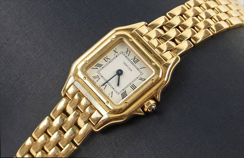 A CARTIER LADY'S 18 KARAT YELLOW GOLD PANTHER WATCH.: A CARTIER LADY'S 18 KARAT YELLOW GOLD PANTHER WATCH. Face: 29.5mm x 24.5mm Wt: 67.9 grams $2,000/$3,000 Quartz movement. Bearing a cabochon sapphire on the crown. Reverse of watch case is stamped