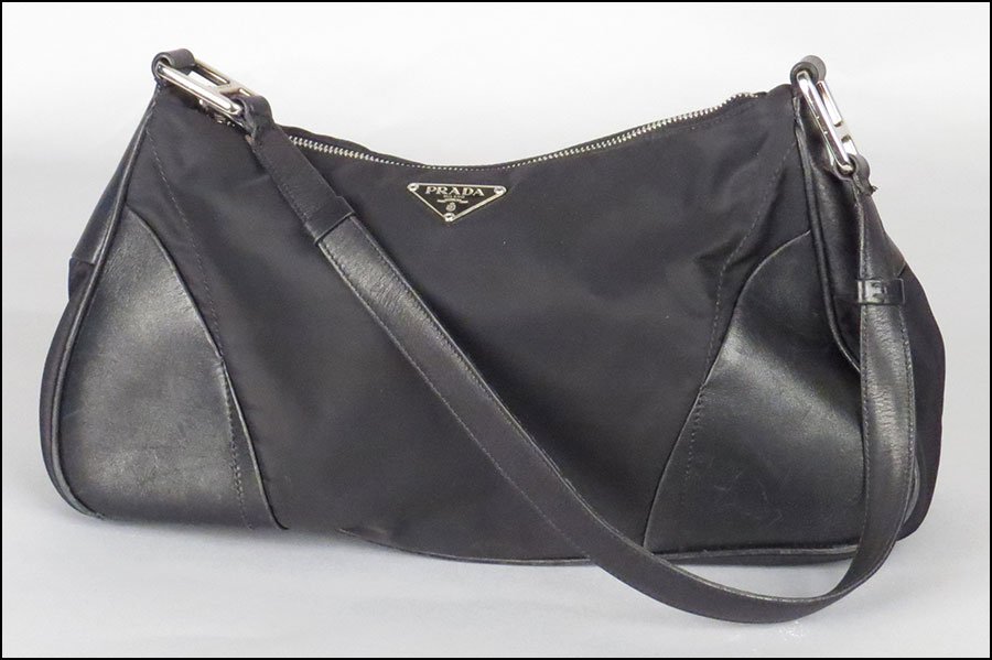 PRADA BLACK LEATHER AND NYLON HANDBAG. 6'' x 13.5'' x: PRADA BLACK LEATHER AND NYLON HANDBAG. 6'' x 13.5'' x 4'' $100/$200 Bearing a signature nylon 'Prada' lining