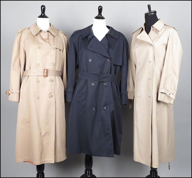 GROUP OF THREE TRENCH COATS. Sizes unlabeled $50/$100: GROUP OF THREE TRENCH COATS. Sizes unlabeled $50/$100 Comprised of a London Fog tan coat, a Evan Picone coat--lined and bearing a removable down liner, and an Aquascutum of London navy coat with a sel