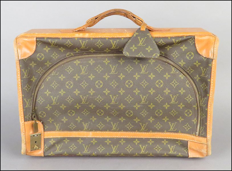 A LOUIS VUITTON MONOGRAMMED CANVAS AND LEATHER PULLMAN: A LOUIS VUITTON MONOGRAMMED CANVAS AND LEATHER PULLMAN SUITCASE. H: 8" W: 20" D: 13" $200/$400 Manufactured by The French Co under special license. Together with an original Louis Vuitton triangular m