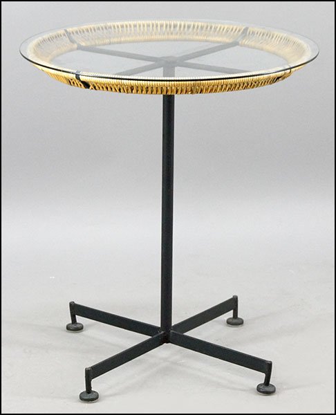 A MID-CENTURY MODERN TABLE.: A MID-CENTURY MODERN TABLE. Comprising a metal base with raffia wrapped edge and a glass top. Attributed to Raymor, but unsigned 30" x 26"